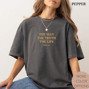 K&ouml;nnte beinhalten: Ein anthrazitfarbenes T-Shirt mit dem Text "THE WAY THE TRUTH THE LIFE" und "JOHN 14:6" in Gold auf der Vorderseite.