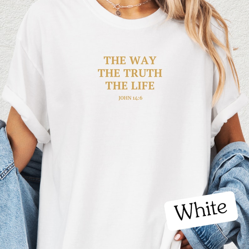 Op de afbeelding: Wit T-shirt met de tekst "THE WAY THE TRUTH THE LIFE" en "JOHN 14:6" in gouden letters.