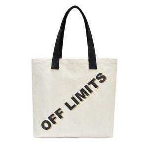 May include: A white canvas tote bag with black handles and the text "OFF LIMITS" printed in black and gold letters.