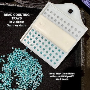 May include: A white plastic bead counting tray with a rectangular insert, featuring rows of 3mm or 4mm holes. The tray is filled with small turquoise seed beads. Text on the image reads: BEAD COUNTING TRAYS in 2 sizes: 3mm or 4mm and Bead Tray: 3mm Holes with size 8/0 Miyuki seed beads.