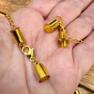 Gold-plated 6.5mm end caps with lobster claw clasp and chain. Plated brass.