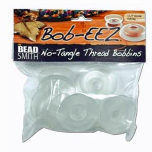 May include: A package of clear plastic bobbins labeled "Bob-EEZ No-Tangle Thread Bobbins" by Bead Smith. The package contains 6 bobbins.