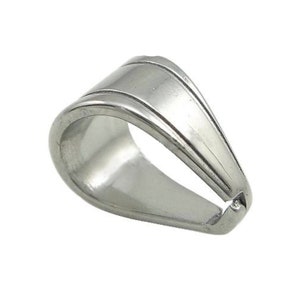 May include: Silver pendant bail with a smooth, rounded shape and a slightly curved design. The bail has a small opening at the top for attaching a pendant.