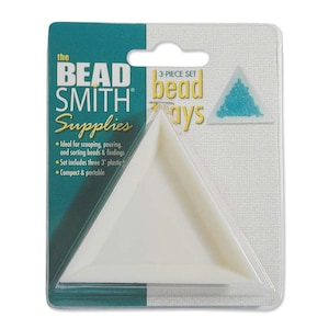May include: A three-piece set of white plastic triangle bead trays. The packaging shows a close-up of one of the trays and a small sample of turquoise beads. The text on the packaging reads "The Bead Smith Supplies 3-Piece Set Bead Trays".