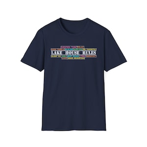 May include: A navy blue t-shirt with a white graphic print that says "Cocktail Time Relax, Hang Towels, Slalom, Bonfire, Be Thankful, Lake House Rules, Sleep In, Hug, Skip Rocks, Fish, Barefoot, Love, Make Memories".
