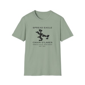 May include: A sage green t-shirt with a black graphic of a map of the Chain O' Lakes in Spread Eagle, Wisconsin. The text "Spread Eagle" and "Chain O' Lakes" are printed in black above and below the map. The text "Spread Eagle, Wisconsin" and "Est. 1857" are printed in black below the map.