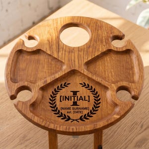 May include: A white ceramic mug with a black handle and the text "But First, Coffee" in a bold, black font. The mug is set against a blurred background, suggesting a cozy setting.