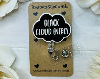 Puede incluir: Carrete de identificación con una nube negra y el texto "Black cloud energy" en blanco. El carrete está unido a un porta-insignias de plástico transparente y un clip plateado.