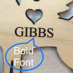 Op de afbeelding: Houten rendier-uitsparing met een hart en de naam GIBBS in vetgedrukte letters.