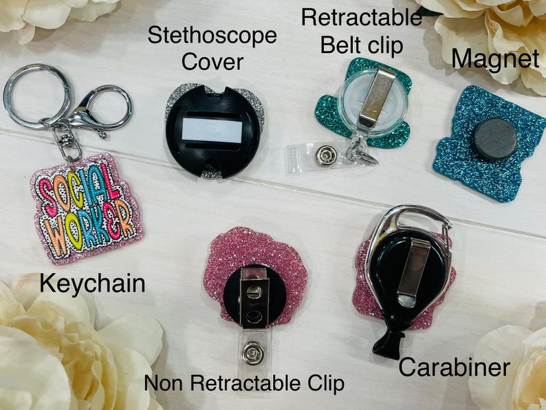 May include: An assortment of accessories, including a keychain with the text "SOCIAL WORKER", a stethoscope cover, a retractable belt clip, a magnet, a non-retractable clip, and a carabiner. The items are in various colors, including pink, teal, and silver.