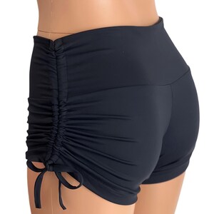 May include: Black athletic shorts with a gathered detail on the back and a drawstring on the side.