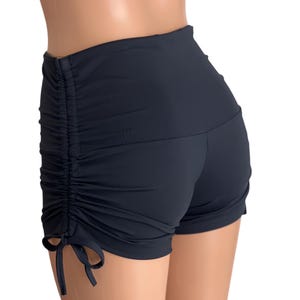 May include: Black high-waisted shorts with a drawstring detail on the sides. The shorts are made of a stretchy, comfortable fabric.