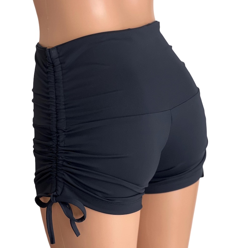 May include: Black high-waisted shorts with a drawstring detail on the sides. The shorts are made of a stretchy, comfortable fabric.