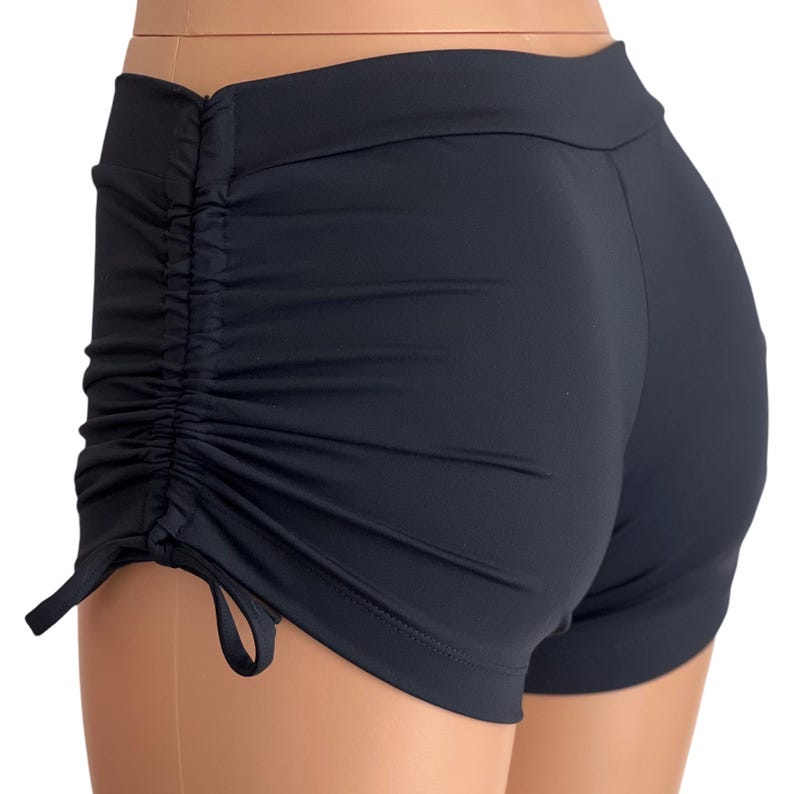May include: Black athletic shorts with a drawstring detail on the sides.