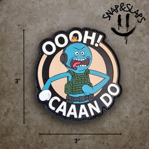 Pode incluir: Um patch de 7,6 cm por 7,6 cm com um personagem de desenho animado com pele azul, usando um fone de ouvido e um colete verde. O personagem está dentro de um círculo preto com as palavras "OOOH! CAAAAN DO" em branco. O patch também tem o texto "SNAP & SLAPS".