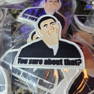 Puede incluir: Un parche blanco y negro con una imagen de dibujos animados de un hombre con el texto "You sure about that?" impreso en él.