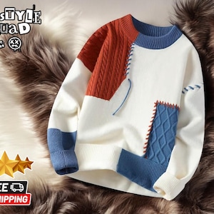 May include: A white, blue, and orange knitted sweater with a patchwork design. The sweater has a crew neck and long sleeves.
