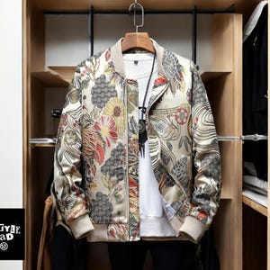 May include: A beige bomber jacket with a floral print. The jacket has a zipper closure and a ribbed collar, cuffs, and hem.