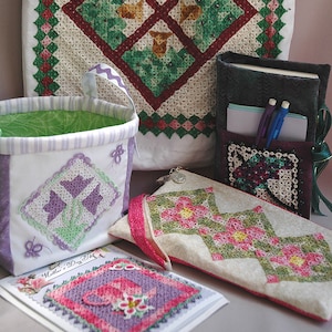 以下が含まれることがあります： 手作りのかぎ針編みアイテムのコレクション。トートバッグ、小さなバスケット、ペンケース、小さなポーチが含まれています。トートバッグは、白地に緑と赤のダイヤモンド模様が施されています。バスケットは白地に緑と白のストライプのライニングが付いています。ペンケースは黒地に紫と白のかぎ針編みのデザインが施されています。ポーチは白地にピンクと緑のかぎ針編みのデザインが施されています。すべてのアイテムは、小さなビーズと花で飾られています。