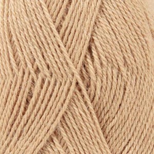 Puede incluir: Una vista de cerca de un ovillo de hilo de color tostado claro, que muestra la construcci&oacute;n de fibra trenzada y la textura suave y mate del hilo. Las hebras est&aacute;n enrolladas en un patr&oacute;n consistente, destacando el grosor uniforme y el color beige.