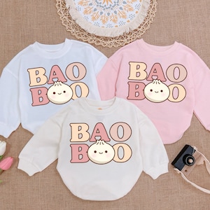 May include: Three white and pink long-sleeved shirts with the text "Bao Boo" and a cartoon bao bun with a face.