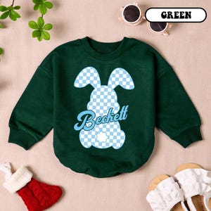 May include: A green long-sleeved sweatshirt with a blue and white checkered bunny graphic and the name "Beckett" in a retro font.