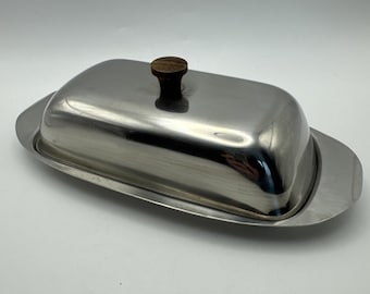 Burriera in acciaio inox con manico in legno a forma di delfino, stile moderno di metà secolo.