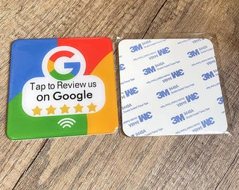 May include: A square sticker with a Google logo, the text "Tap to Review us on Google", and five stars. The sticker is on a wooden surface and has a clear adhesive backing.