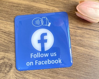 May include: Blue square sign with a white Facebook logo and the text "Follow us on Facebook". A white icon of a phone with a contactless payment symbol is above the logo.