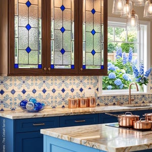 May include: A kitchen with blue cabinets and a marble countertop. The upper cabinets have stained glass doors with blue diamond accents. Copper pots and pendant lights hang above the island. A window overlooks a garden.