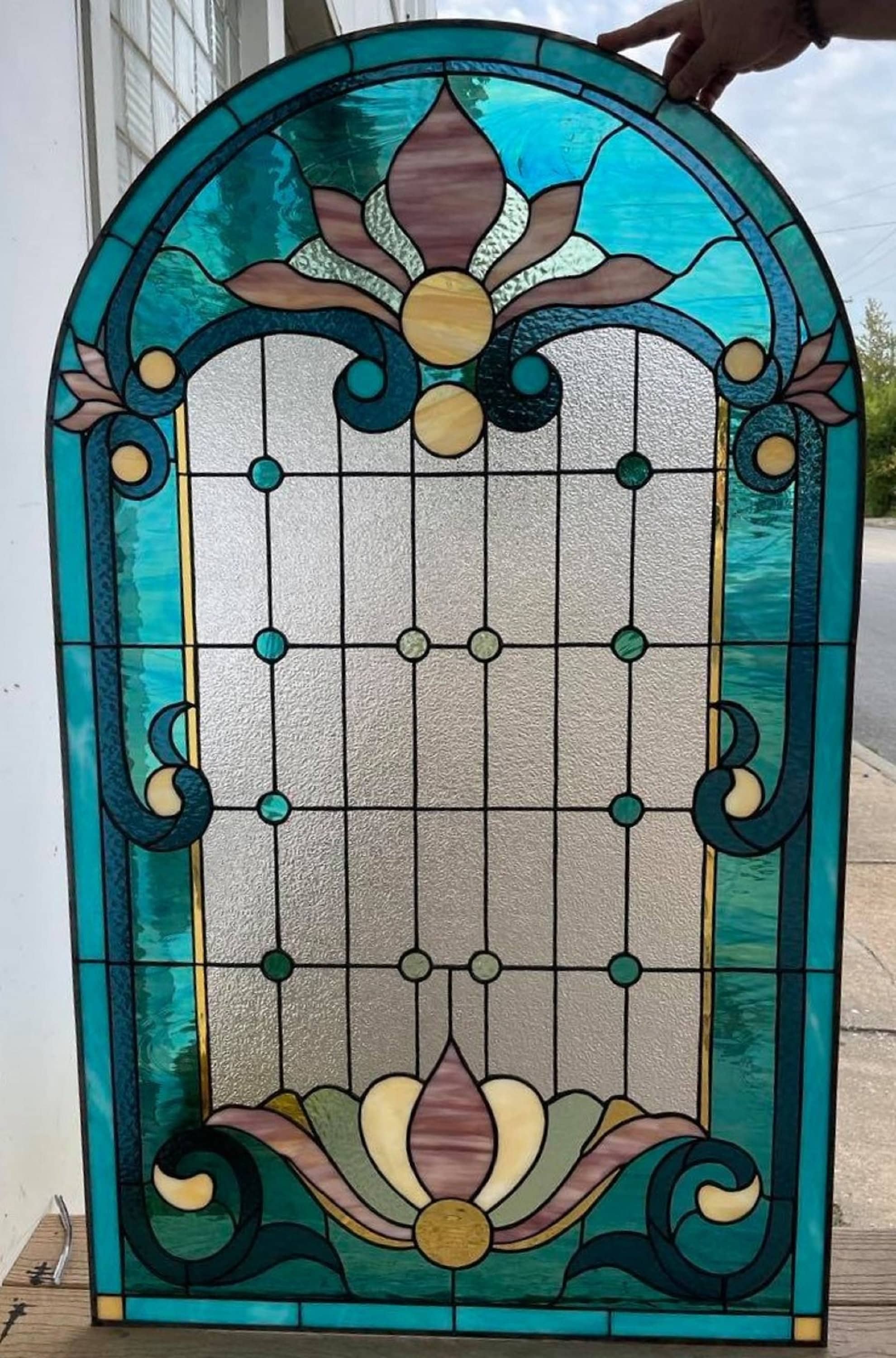 Large blue-green arched stained glass...
