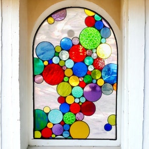 May include: A stained glass window with a colorful design of overlapping circles in shades of red, green, blue, yellow, purple, and orange.