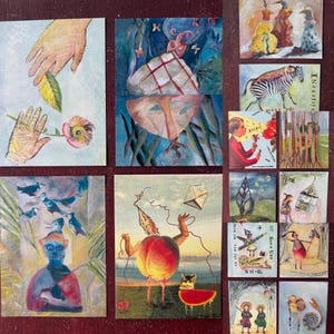 May include: A set of nine colorful postcards featuring various abstract and surreal illustrations. The postcards are printed on thick cardstock and have a matte finish. The illustrations include a peach with legs, a zebra, a hand holding a flower, and a bird with a fish.