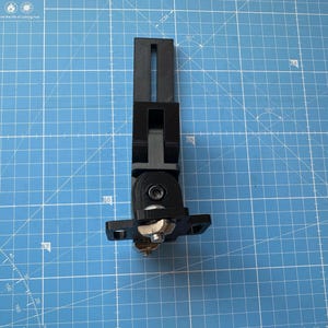May include: A black 3D printed camera mount with a ball joint and a slot for a camera. The mount is designed to be adjustable and can be used to mount a camera to a variety of surfaces.