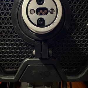 May include: Close-up of a black exercise bike with a silver and black sensor, a black adjustment knob, and a red "START STOP" button.