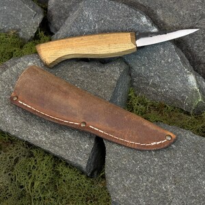 Leather knife sheath with wooden knife handle partially visible, fitted knife cover for carving tools