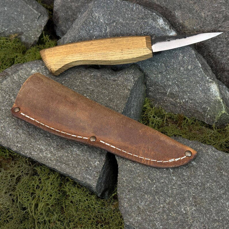 Leather knife sheath with wooden knife handle partially visible, fitted knife cover for carving tools