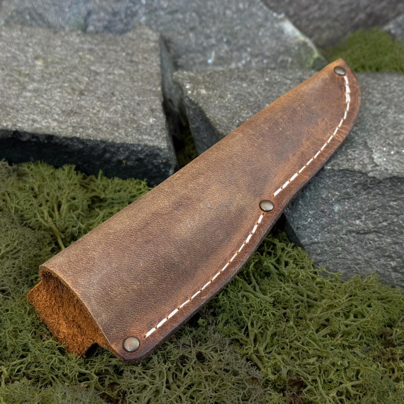 Brown Crazy Horse leather knife sheath with stitched edges, minimalist leather knife cover shown outdoors