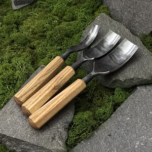 May include: Three woodworking gouges with polished metal curved blades and light brown wooden handles. Each tool features a distinctively shaped steel head designed for carving, with a smooth, straight-grained wooden grip for manual control.