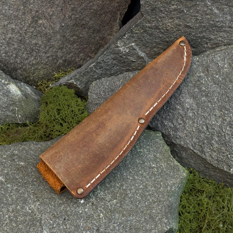 Leather knife sheath laid flat on stone background, universal leather knife cover for bushcraft knives