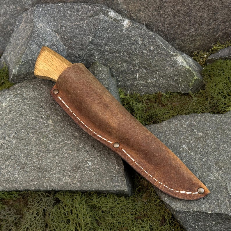Universal leather knife sheath displayed on stone surface, handcrafted leather knife holder for bushcraft use
