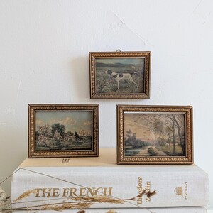 Trio d'oeuvres d'art encadrées antiques | Cadres en bois doré | Paysages pastoraux et chien de chasse