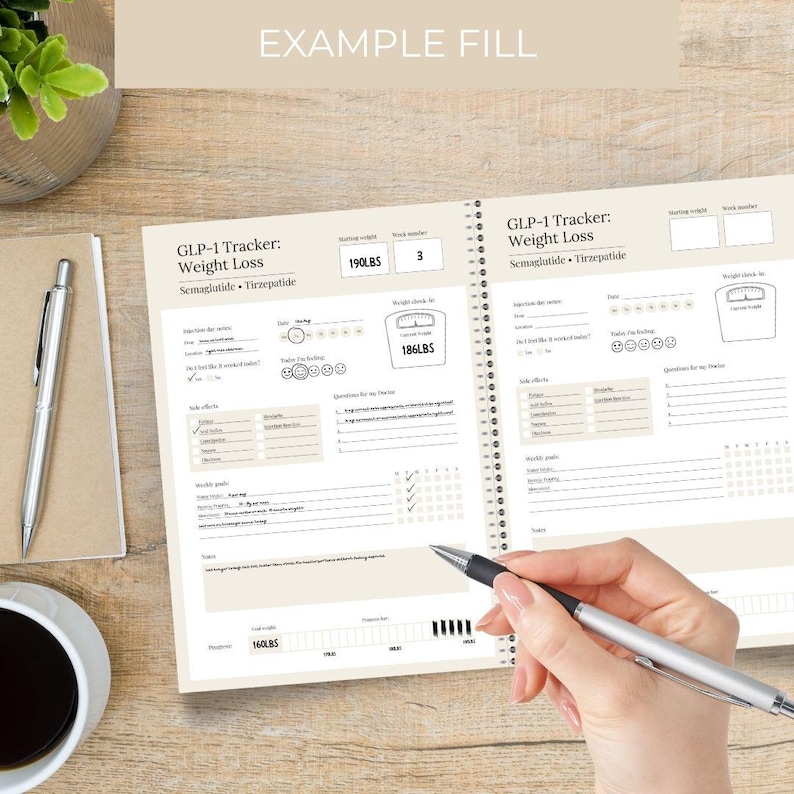 Puede incluir: Un cuaderno de seguimiento de p&eacute;rdida de peso abierto con el texto "GLP-1 Tracker: Weight Loss Semaglutide Tirzepatide". El cuaderno presenta secciones de control de peso y espacio para notas. Un bol&iacute;grafo se sostiene sobre el cuaderno.