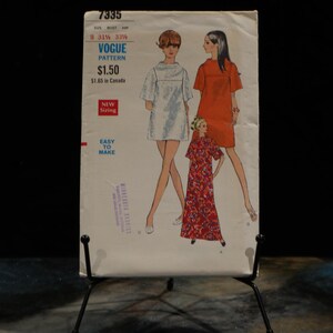 May include: A vintage Vogue Pattern, number 7335, depicting three women in dresses. The cover displays the text "Vogue Pattern" and "Easy to Make". The dresses are in white, orange, and a red floral print.