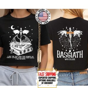 May include: Black crop top with a white graphic of a dragon, books, and text. The front of the shirt has the text "I AM THE SKY AND THE POWER OF EVERY STORM THAT HAS EVER BEEN. I AM INFINITE." The back of the shirt has the text "BASGIATH WAR COLLEGE."