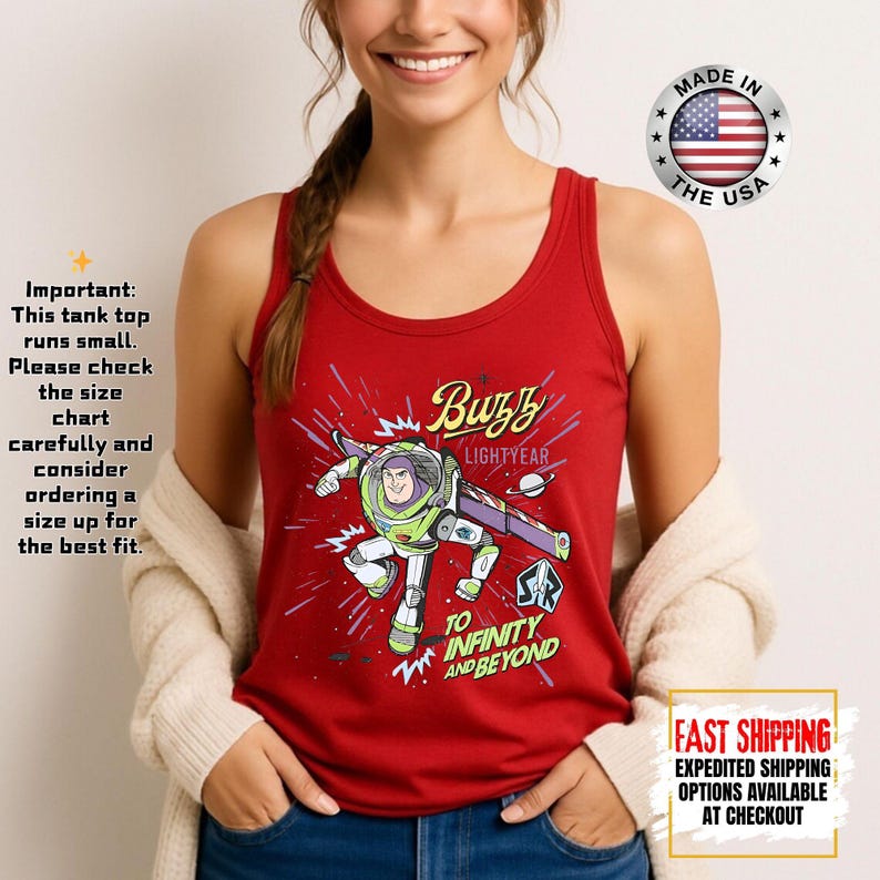 May include: Red tank top with a Buzz Lightyear graphic and the phrases "Buzz Lightyear" and "To Infinity and Beyond." The tank top has a racerback design and is made in the USA.