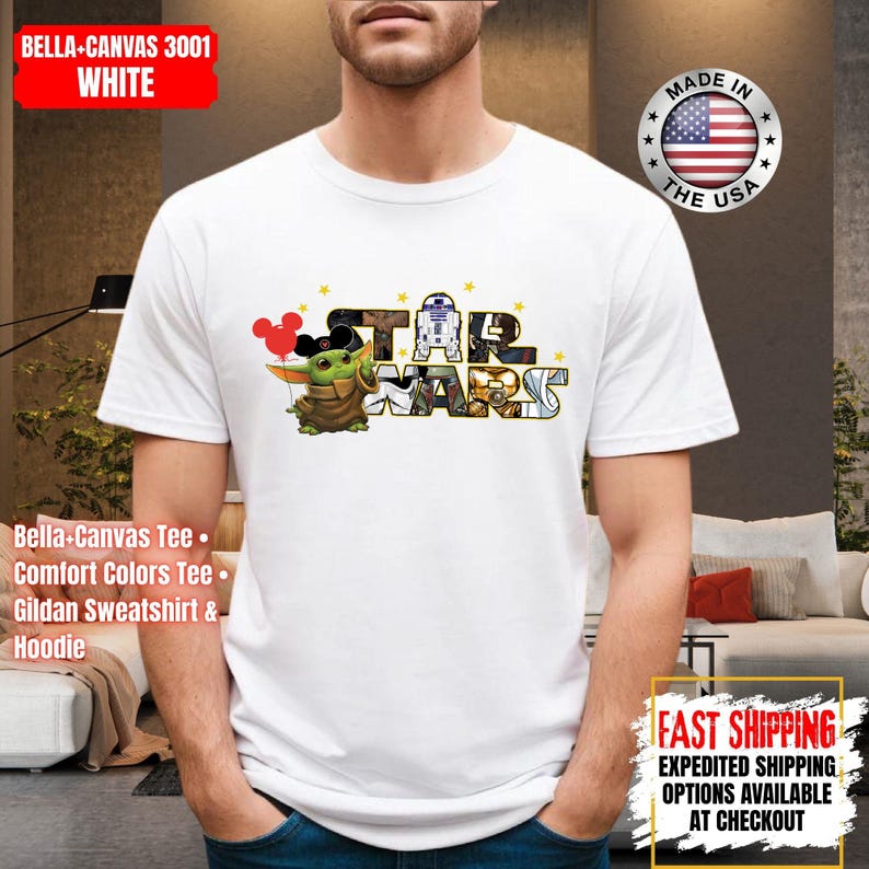 May include: White t-shirt featuring a colorful "Star Wars" graphic with Baby Yoda and R2-D2. The shirt includes the text "STAR WARS" in a stylized font. The shirt is a Bella+Canvas 3001, and the image also includes the text "Made in the USA".