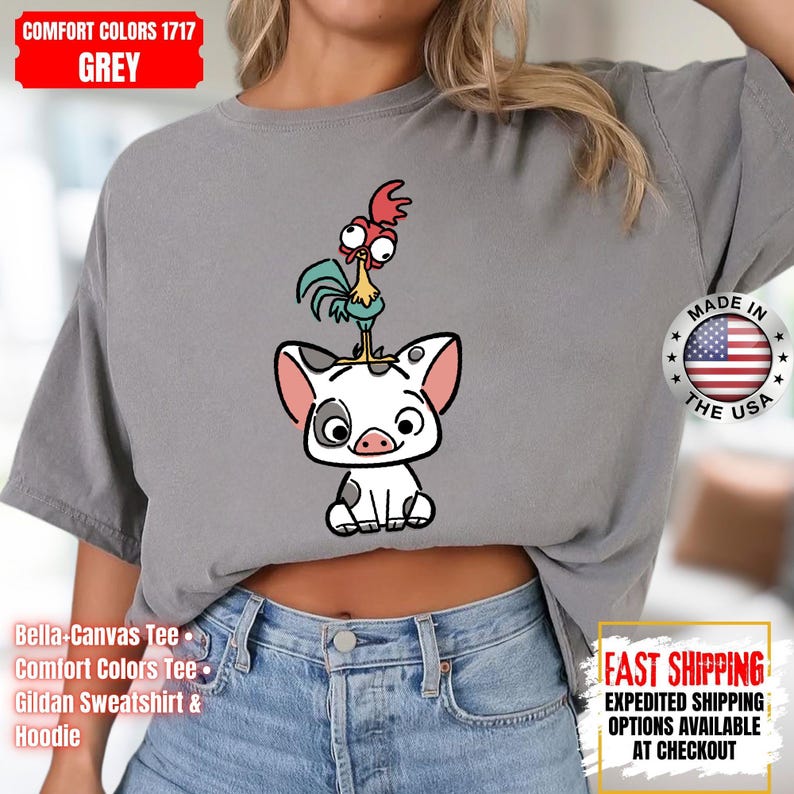 K&ouml;nnte beinhalten: Graues Comfort Colors T-Shirt mit einem Cartoon-Schwein und Hahn-Design. Das Shirt tr&auml;gt den Text "MADE IN THE USA" und "FAST SHIPPING". Es ist ein Bella-Canvas Tee, Comfort Colors Tee oder Gildan Sweatshirt & Hoodie.