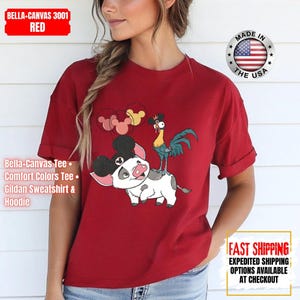 May include: Red Bella+Canvas 3001 tee featuring a cartoon pig with Mickey Mouse ears and a rooster. The shirt also has the text "Bella-Canvas Tee, Comfort Colors Tee, Gildan Sweatshirt & Hoodie".