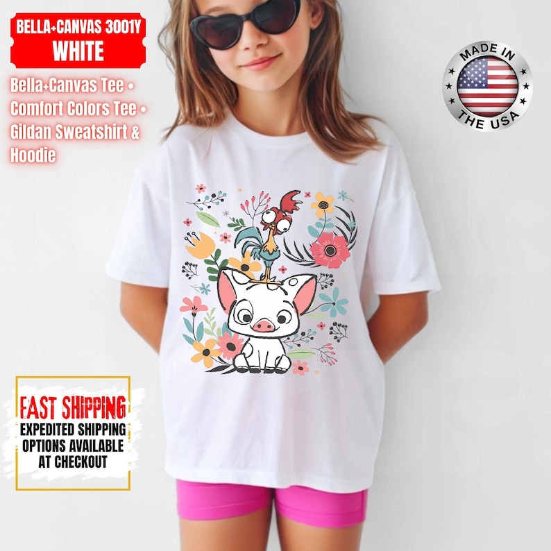 May include: White t-shirt with a cartoon pig and rooster design, surrounded by flowers. The shirt has the text "BELLA-CANVAS 3001Y WHITE" and "MADE IN THE USA". Part of the Bella-Canvas Tee, Comfort Colors Tee, and Gildan Sweatshirt & Hoodie range.